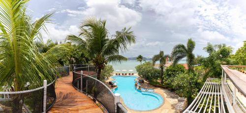 a resort with a swimming pool with a view of the ocean at Aochalong Villa Resort & Spa - SHA Plus in Chalong