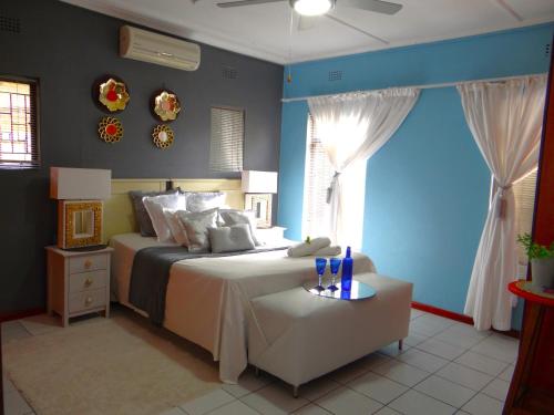 1 dormitorio con cama y pared azul en Alakhe Self-Catering Accomodation Twin Bedroom, en Oudtshoorn