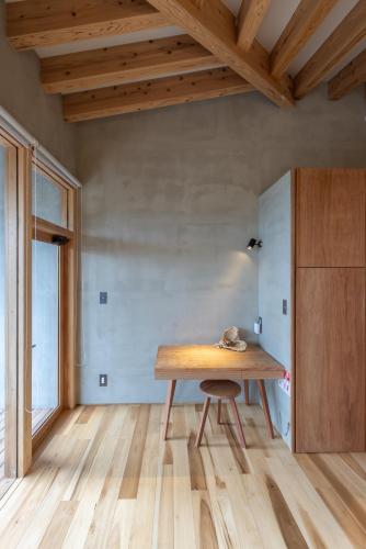 a dining room with a wooden table and a window at Amami 与庵 in Amami