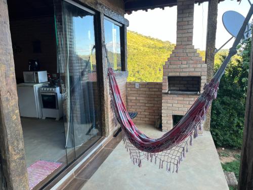 a hammock on a screened in porch of a house at Chalé Póca in Conceição da Ibitipoca