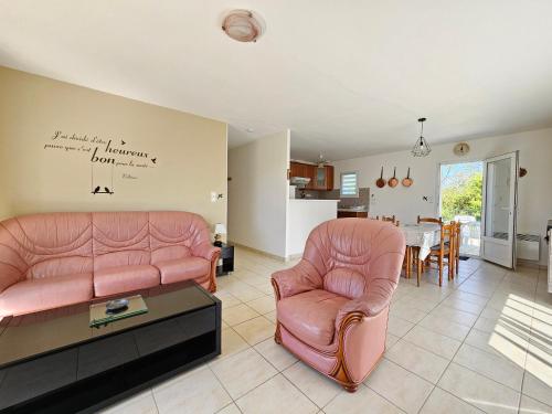 - un salon avec deux chaises roses et une table dans l'établissement Charmante maison entre mer et campagne, calme, proche plages, Saint-Michel-en-l'Herm, 4 pers. - FR-1-476-41, à Saint-Michel-en-lʼHerm