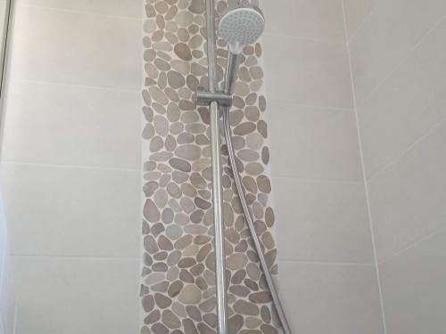 une douche avec un rideau de douche en pierre dans une salle de bain dans l'établissement Maison Cosy, Rénovée, Proche Plage et Centre, Jardin, Animaux Bienvenus - FR-1-652-19, à Saint-Jean-de-Monts