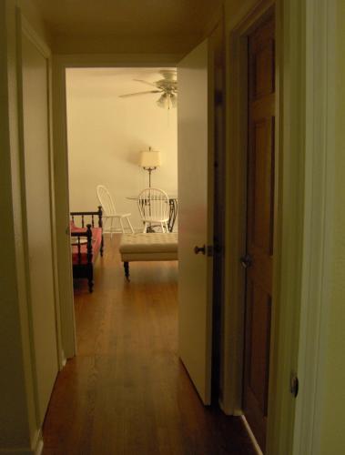 un corridoio con una sedia e un tavolo in una stanza di Mid-Century Modern meets Cajun Creole a Baton Rouge