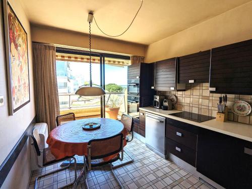 une cuisine avec une petite table et une cuisine avec une fenêtre dans l'établissement Grand Appartement avec Terrasse, Clim, WIFI et Parking à Arcachon - FR-1-420-144, à Arcachon