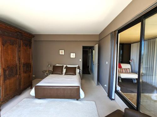 une chambre avec un lit et une grande fenêtre dans l'établissement Grand Appartement avec Terrasse, Clim, WIFI et Parking à Arcachon - FR-1-420-144, à Arcachon