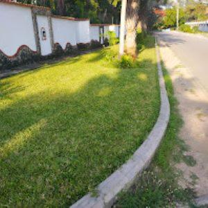 a grassy yard next to a street with a sidewalk at 3RD Ave. Beach Apartment Nyali, Mombasa, North Coast in Nyali