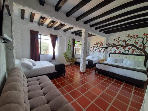 Habitación grande con 3 camas y sofá. en HOTEL LA VILLA DE LUISA EN VILLa DE LEYVA, en Sáchica