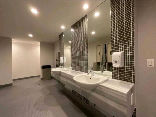a bathroom with a sink and a large mirror at CN Tower View w/ Free Parking, Pool & Gym and More in Toronto