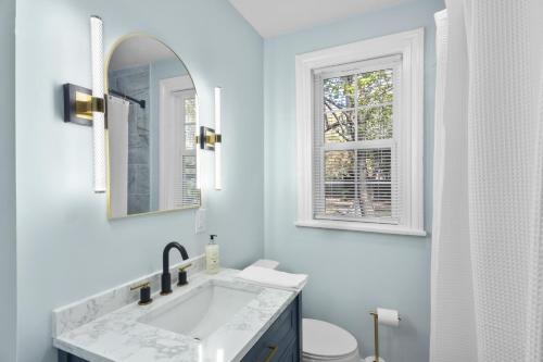 a white bathroom with a sink and a window at Forest Hills Manor in Augusta