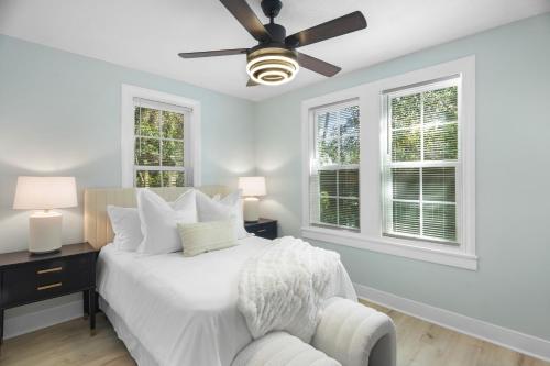 a white bedroom with a bed and a ceiling fan at Forest Hills Manor in Augusta