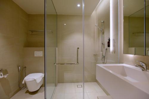 a bathroom with a shower and a sink and a toilet at Cititel Express Kota Kinabalu in Kota Kinabalu