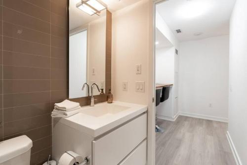een badkamer met een wastafel en een spiegel bij Luxe 2 Bed Suite Downtown Toronto Near Waterfront in Toronto