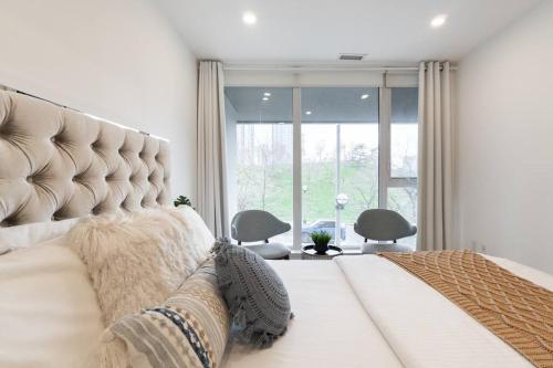 een slaapkamer met een groot bed en een groot raam bij Luxe 2 Bed Suite Downtown Toronto Near Waterfront in Toronto