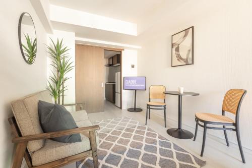 a living room with chairs and a table and a tv at Dash Living Ueno Park in Tokyo