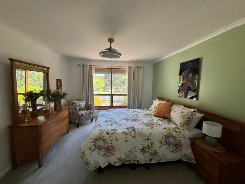 a bedroom with a bed and a dresser and a window at Cin Cin at Mclaren in McLaren Vale