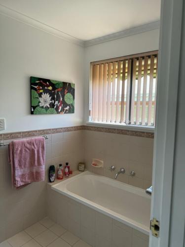 a bathroom with a bath tub and a window at Cin Cin at Mclaren in McLaren Vale