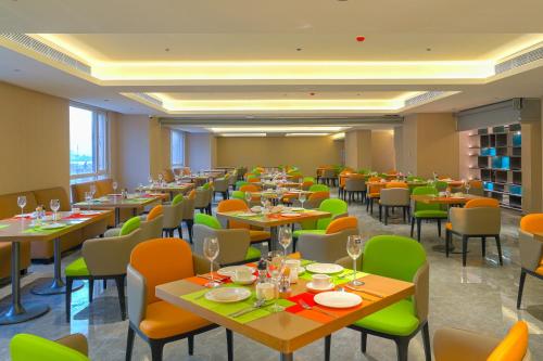 - un restaurant avec des tables et des chaises dans une salle dans l'établissement Tianjin Polar Ocean Hotel, à Binhai