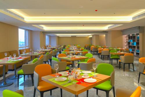 a restaurant with tables and chairs in a room at Tianjin Polar Ocean Hotel in Binhai