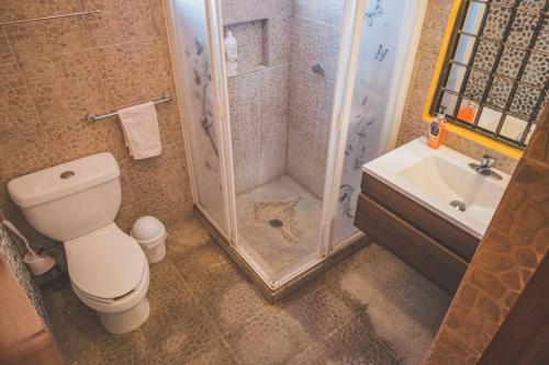 a bathroom with a shower and a toilet and a sink at Casa Vacacional, Lomas Cocoyoc in Texcalpan