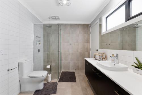 La salle de bains est pourvue de toilettes, d'un lavabo et d'une douche. dans l'établissement Luxury Holiday Home, San Remo - Phillip Island, à San Remo