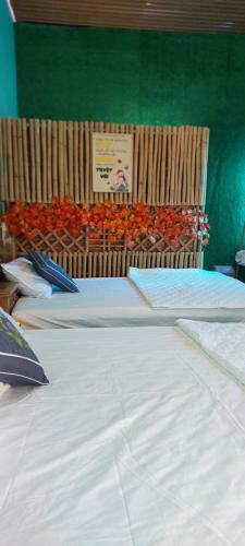 2 camas en una habitación con una pared verde en Cần Thơ Farmstay, en Can Tho