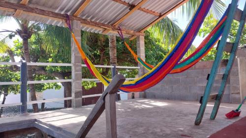 een hangmat met kleurrijke draden aan een dak bij Punta Chilama in La Libertad