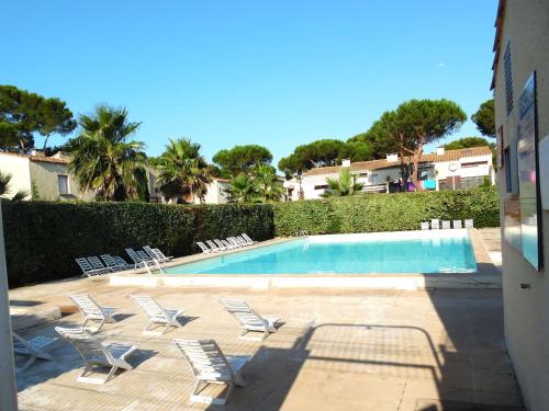 une piscine avec des chaises longues et une piscine dans l'établissement Studio cabine rénové 4 pers. avec piscine, parking privé, proche mer et village naturiste - FR-1-607-193, au Cap d'Agde
