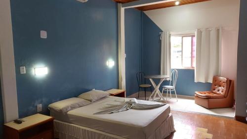 1 dormitorio con cama y pared azul en PLAZA HOTEL MARABÁ, en Marabá