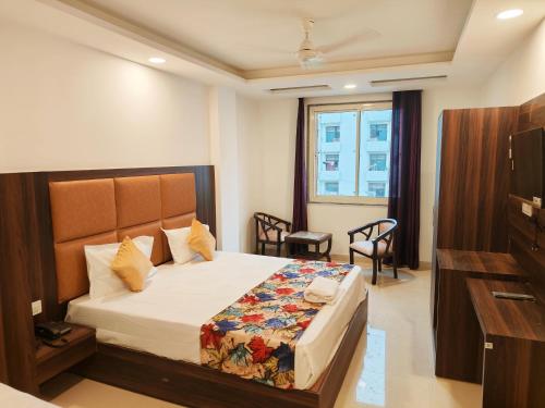 um quarto de hotel com uma cama e uma televisão em Hotel Tela Suite Plaza Near IGI Airport em Nova Deli