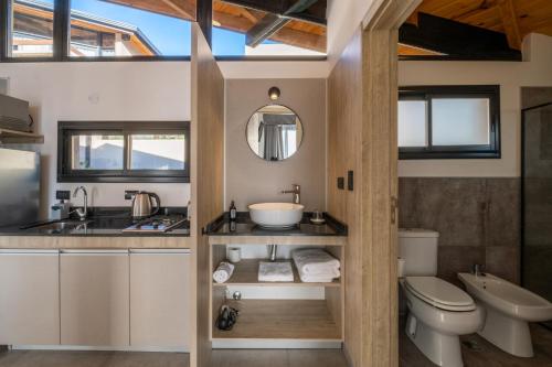 La salle de bains est pourvue d'un lavabo, de toilettes et d'un miroir. dans l'établissement Bonaire Aparthotel, à Villa General Belgrano