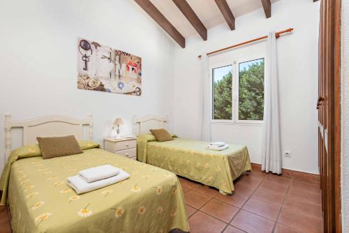 - une chambre avec 2 lits et une fenêtre dans l'établissement Villa Nuria Bosch, à Cala'n Bosch