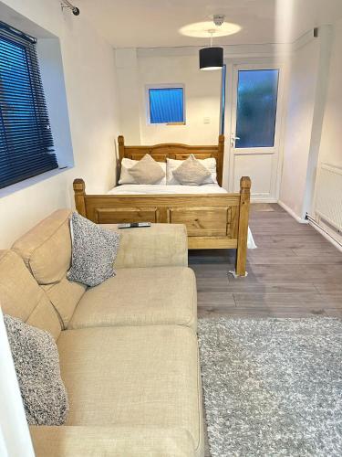 uma sala de estar com um sofá e uma cama em Stevenage Studios - Master Suite em Stevenage