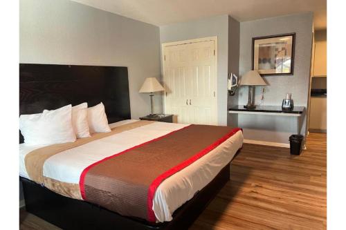 1 cama grande en una habitación de hotel con 2 lámparas en High Five Inn By OYO Killeen, en Killeen