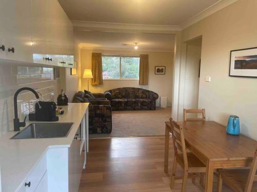 cocina y sala de estar con fregadero y mesa en Forests Edge en Katoomba