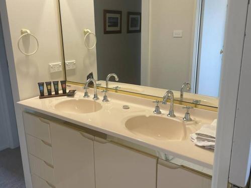 a bathroom with two sinks and a large mirror at Forests Edge in Katoomba