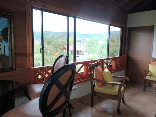 einen Balkon mit Stühlen und Bergblick in der Unterkunft Rancho Papa Cole in Inoa
