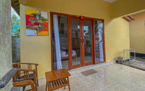 a room with sliding glass doors and a table and chairs at The Salang Guest House in Nusa Penida