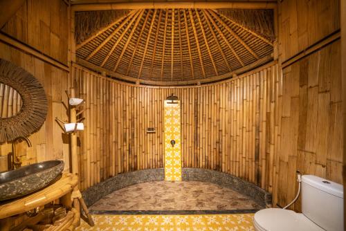 The Dewi Eco Bamboo Villa في كوبوبانلوكان: حمام مع مرحاض في غرفة الخيزران