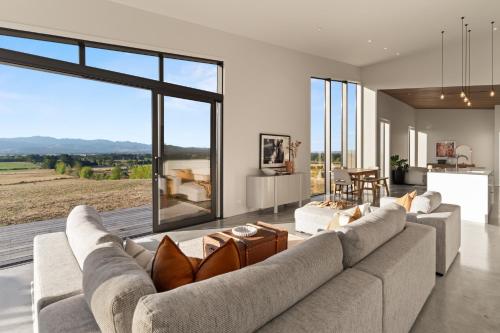 a living room with two couches and a large window at Tiffin Hill in Parkvale