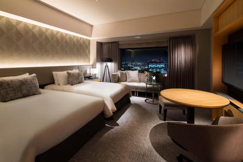 a hotel room with two beds and a table at Cerulean Tower Tokyu Hotel, A Pan Pacific Partner Hotel in Tokyo