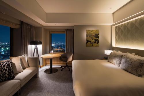 a hotel room with a bed and a couch at Cerulean Tower Tokyu Hotel, A Pan Pacific Partner Hotel in Tokyo
