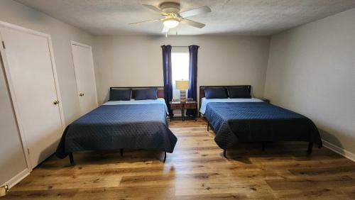 Fentress McMahan的住宿－Cozy Space Near Rough River Lake Adventures Await，一间卧室配有两张床和吊扇