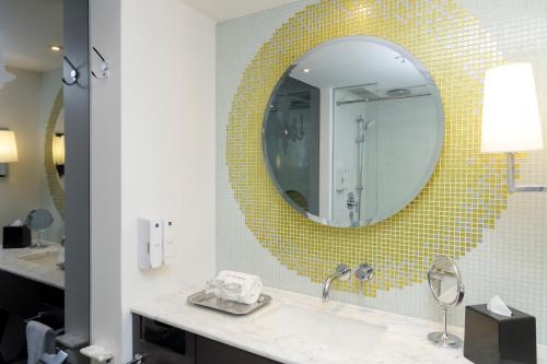 uma casa de banho com um lavatório e um espelho em The Luxe Manor em Hong Kong