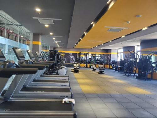 a gym with rows of treadmills and machines at Căn Hộ The Manor Crown in Thôn Trường Giang
