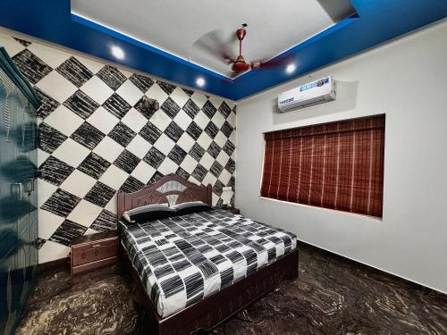 a bedroom with a bed with a checkered wall at Chilanka Place HOME AWAY FROM HOME - Ernakulam- Kerala in Cochin