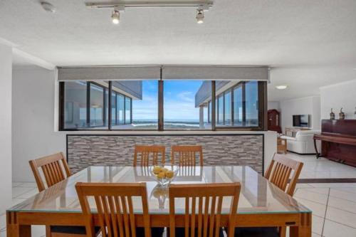 a dining room with a table and chairs with a view at Maroochydore Riverfront Apartment in Maroochydore