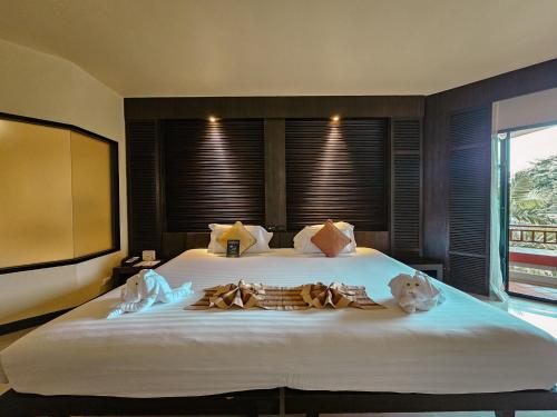 a bedroom with a large bed with two dogs on it at The Nouveau Chumphon Beach Resort And Golf in Chumphon
