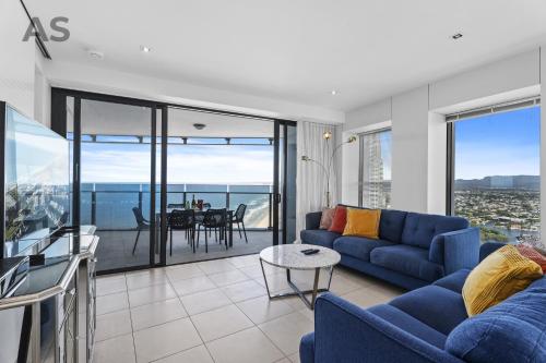 a living room with a blue couch and a table at Soul - Private Apartments - Apartment Stay in Gold Coast