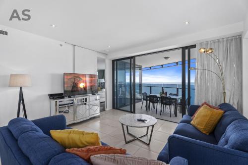 a living room with blue couches and a view of the ocean at Soul - Private Apartments - Apartment Stay in Gold Coast