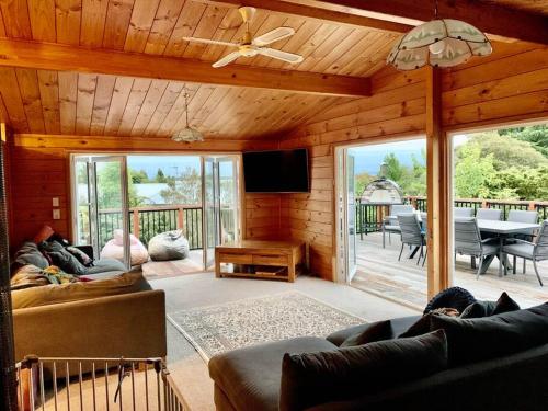 a living room with a couch and a tv and a table at Soak in Cedar Tub, Stroll to Havelock Village in Havelock North